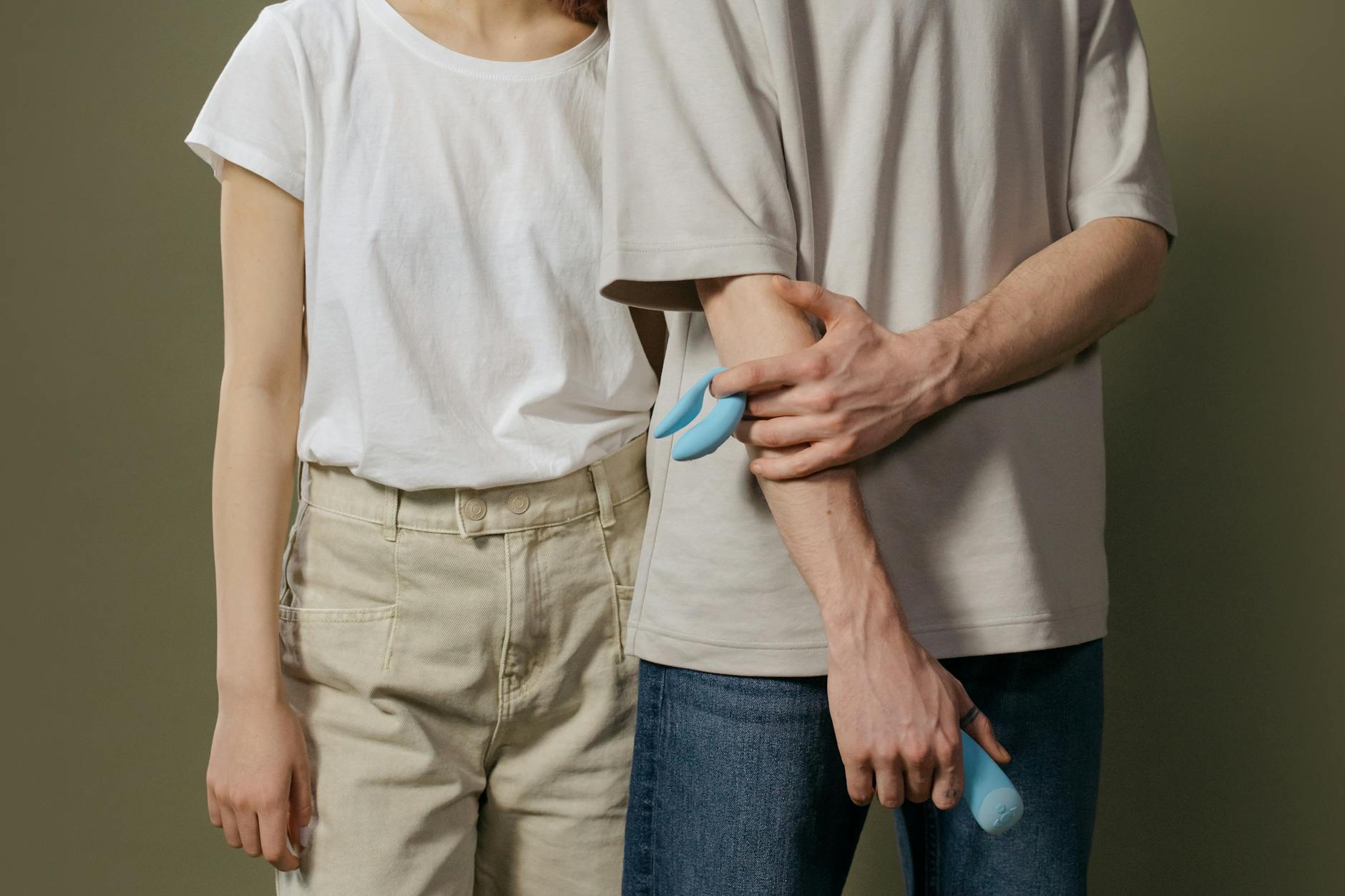 A young couple standing together indoors, exploring intimacy with modern pleasure tools