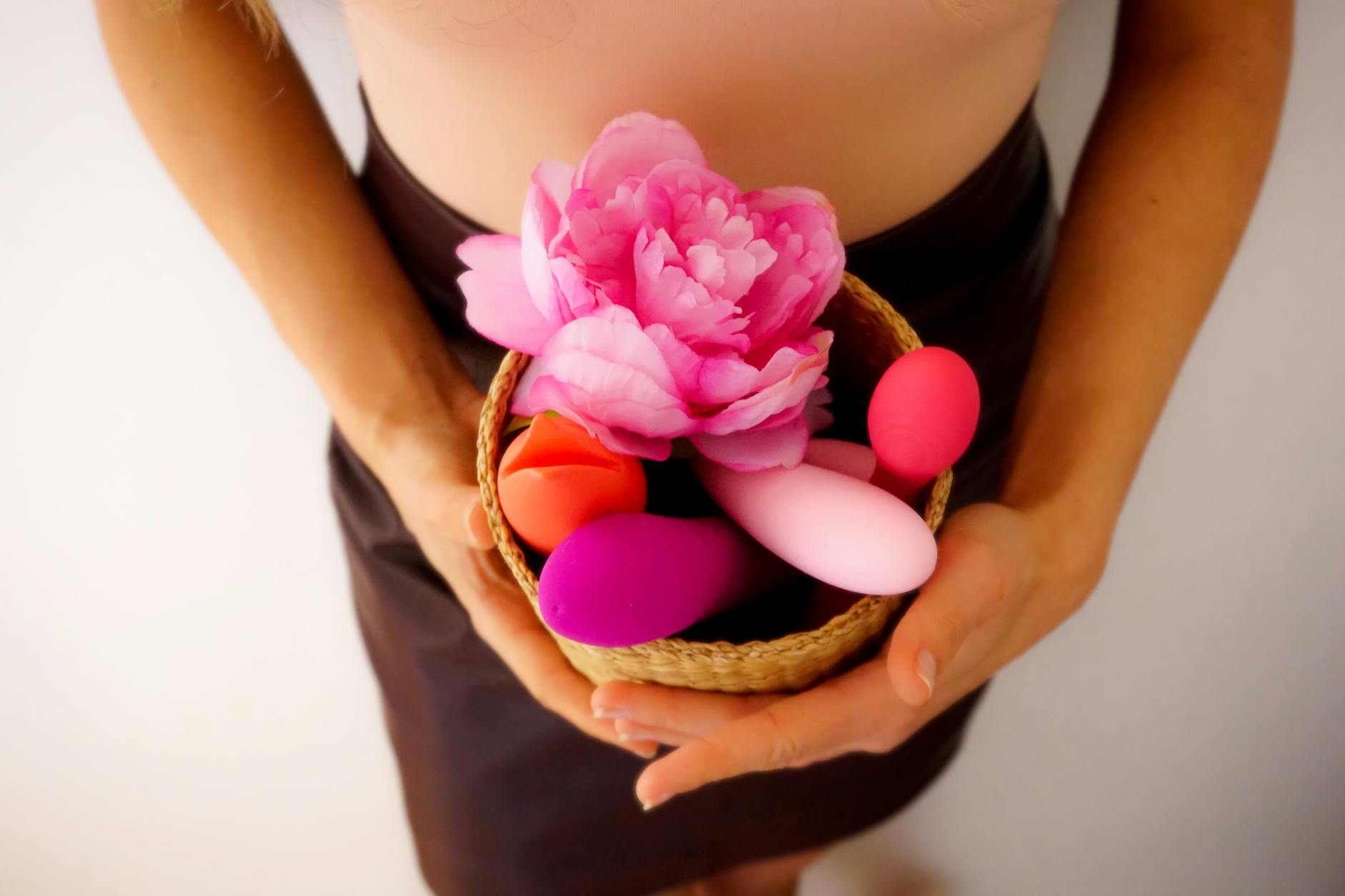 A collection of colorful vibrators and sensual items arranged with fresh flowers